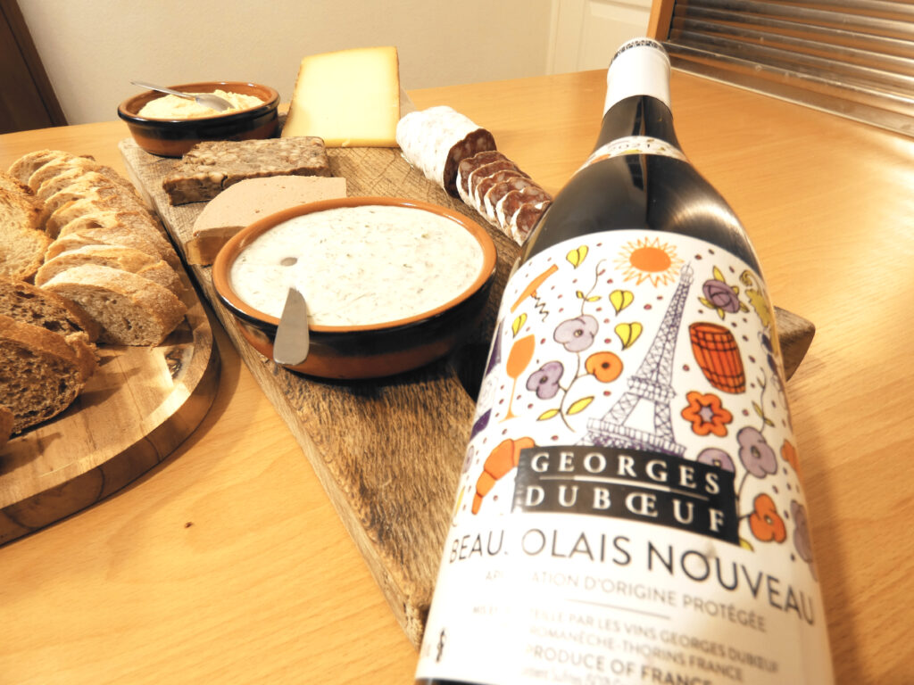 Picture of an iconic beaujolais wine from Georges DuBoeuf and a charcuterie board