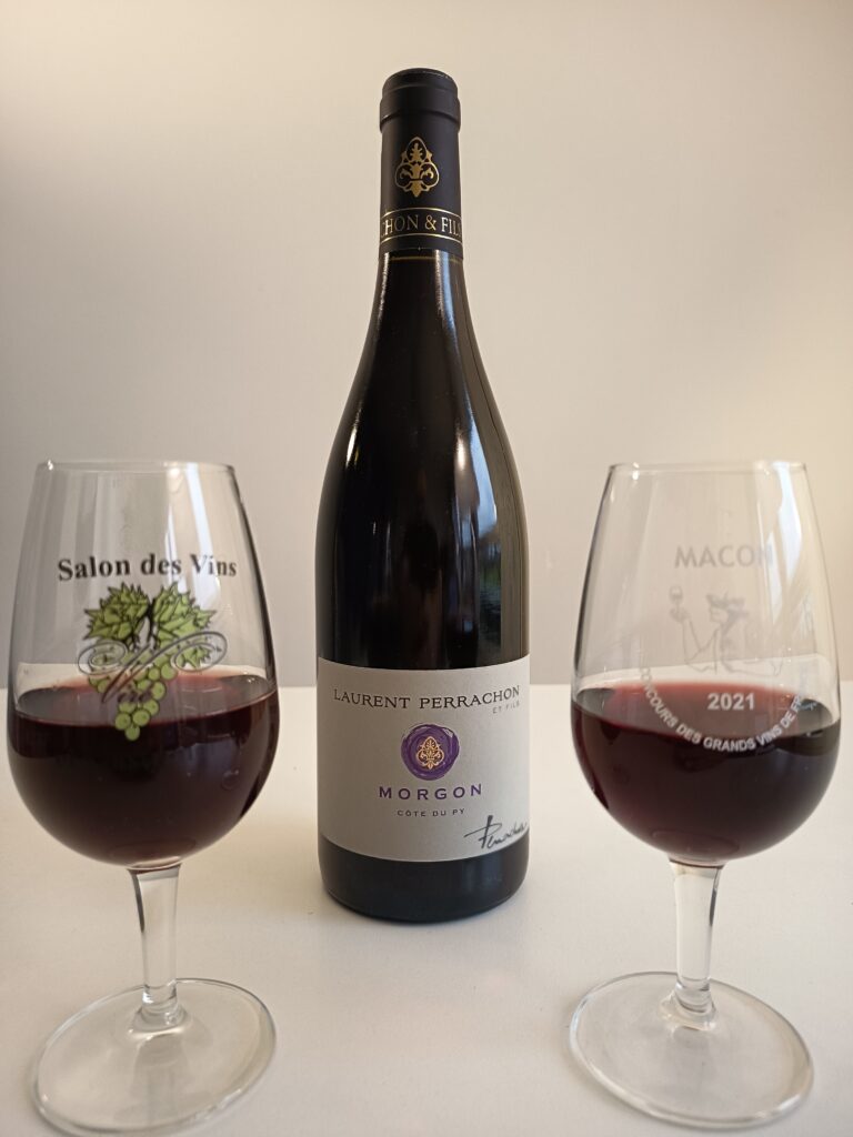 A focus on the bottle of Morgon Côte Du Py from Laurent Perrachon winery. along with two nice glasses of beaujolais wine.