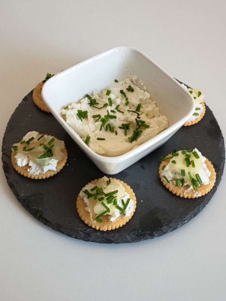 Cottage cheese with aromatic herbs and olive oil. Plate with crackers cheese toast.