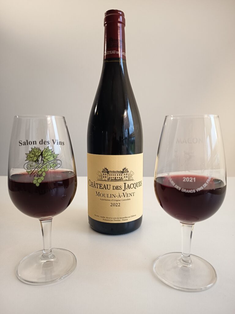 Focus on a Moulin à Vent Beauolais wine from Château des Jacques and two glasses of wine.