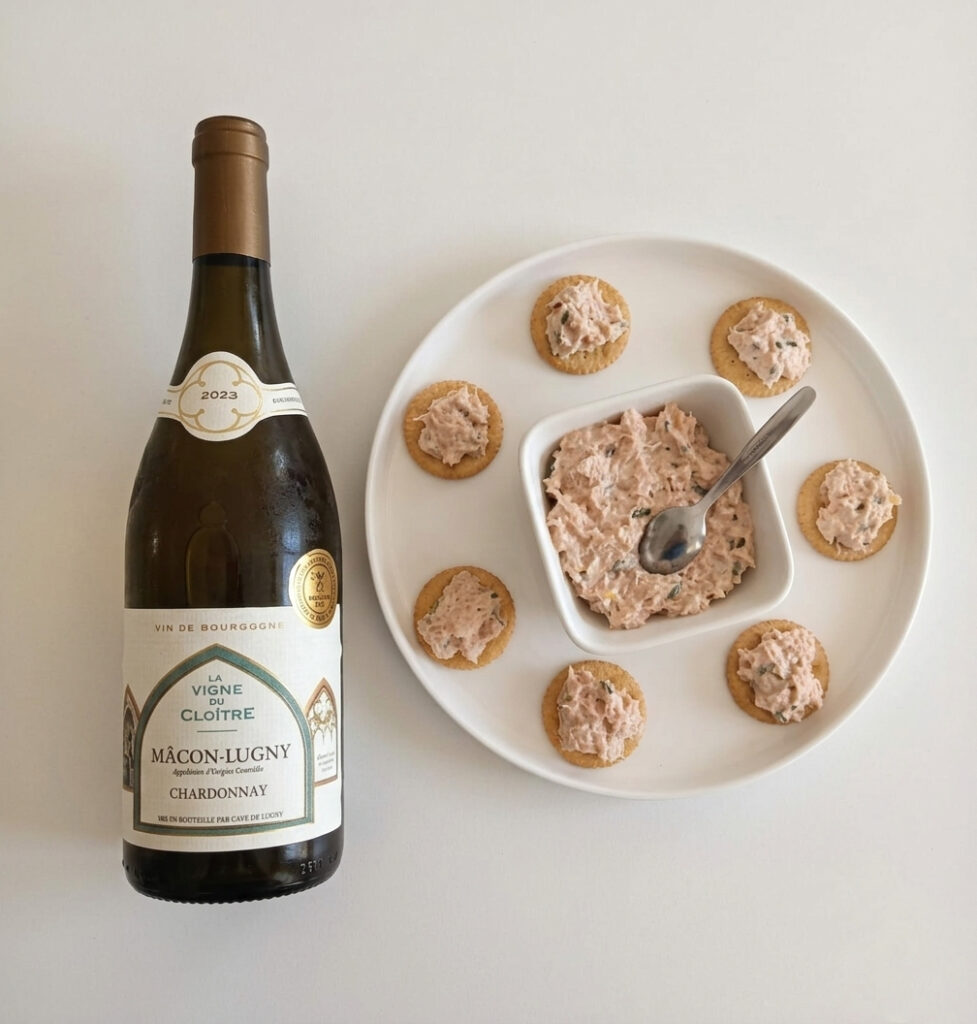 Salmon rillettes appetizer with smoked and fresh salmon on crackers paired with a chilled Mâcon-Lugny Chardonnay from Burgundy, served on a white plate for an elegant French apéritif food and wine pairing.